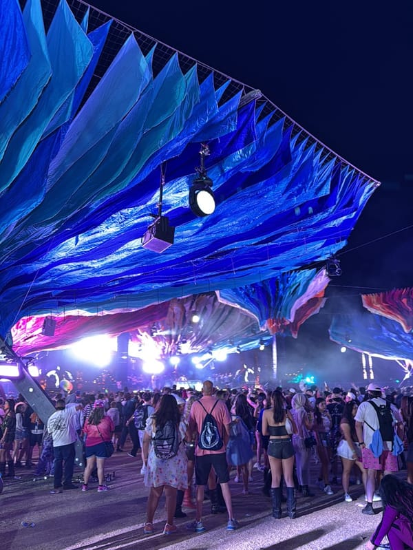 Nighttime crowd gathers under illuminated tents at Indio music festival