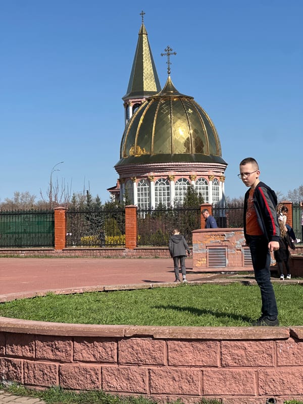 Boy observed near golden-domed church in sunny Kyiv scene