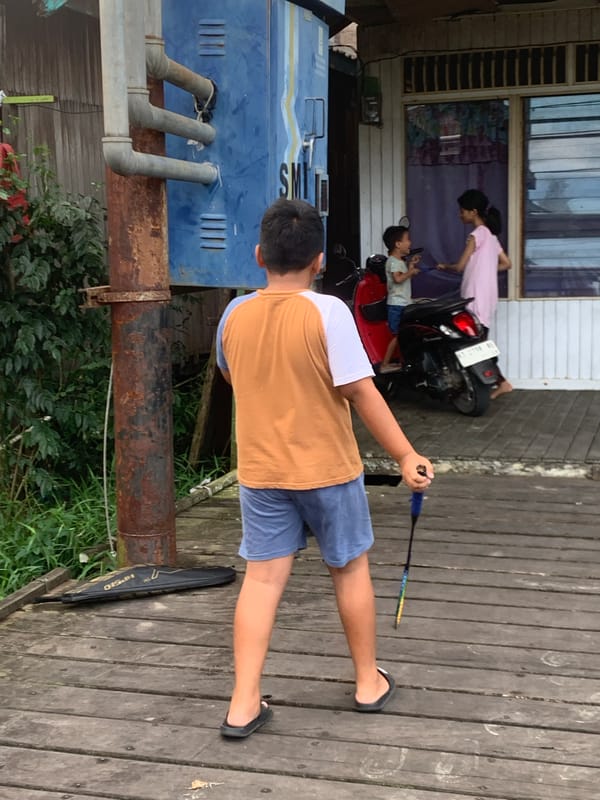 Children play badminton in Indonesian village morning scenes