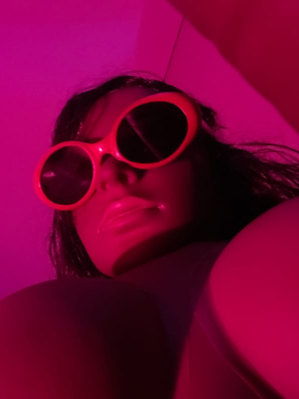 Colorful sunglasses and pink lighting in a disco-glam room