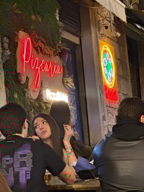 Nighttime crowd gathers in illuminated Catania square