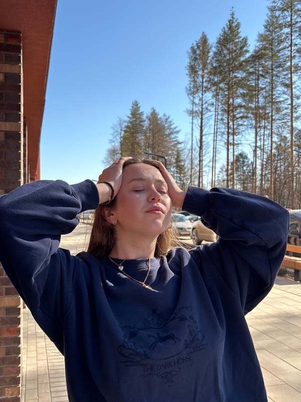 Woman in trench coat photographed around Izhevsk buildings