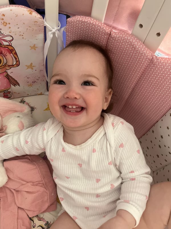 Baby plays and laughs in crib in Shushary