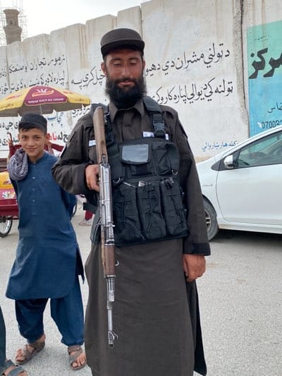 Armed soldier photographed standing against wall in Kandahar