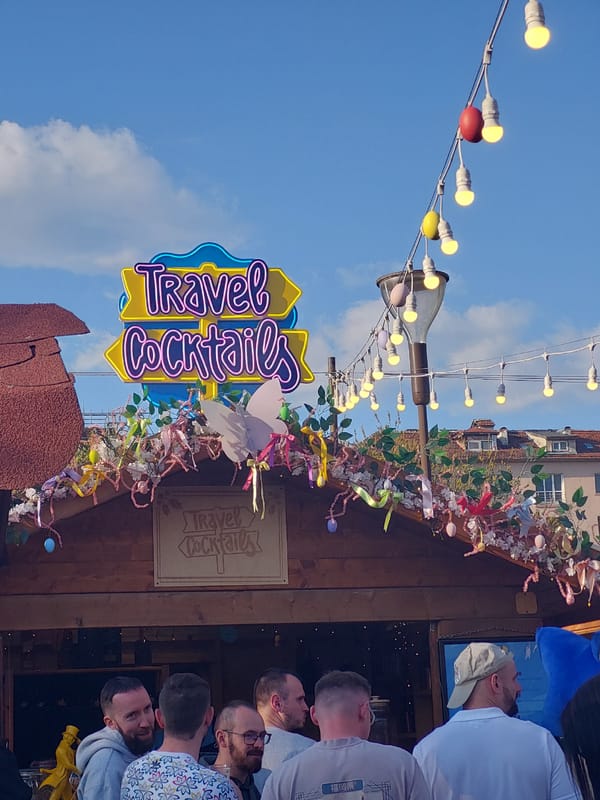 Outdoor market festival documented with Ferris wheel, beverages, murals