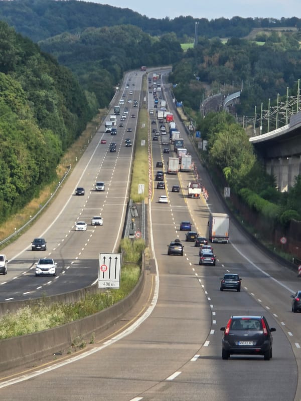 Rural German highway lined with dense trees and concrete barriers