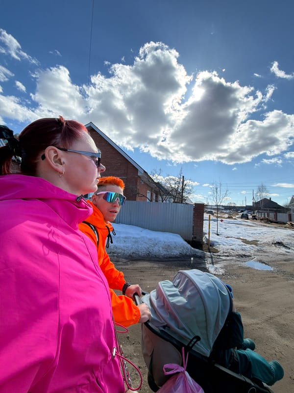 Couple with baby stroller walks residential streets in Chaikovsky