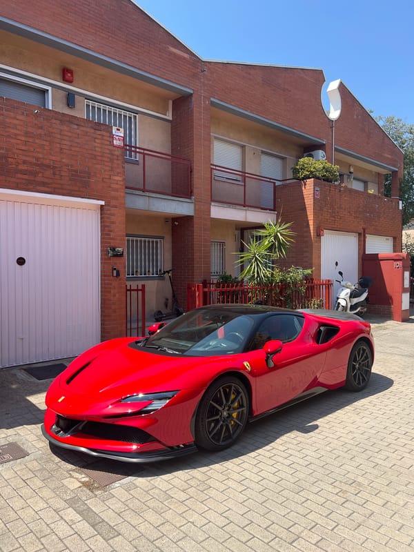 Red Ferrari parked on a brick street in Mollet del Vallès