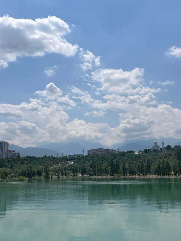 Big Almaty Lake glows turquoise under a clear summer sky