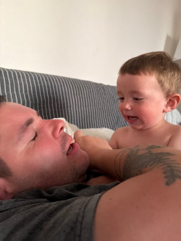 Playful couch moment between adult and child at home