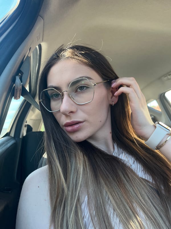 Woman with glasses observed in car driver's seat