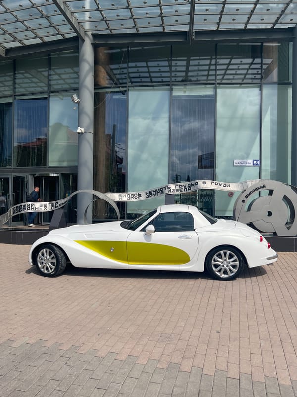 White convertible parked near modern building in Yekaterinburg