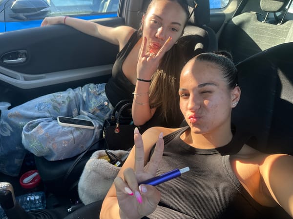 Young women take selfie with vape in car