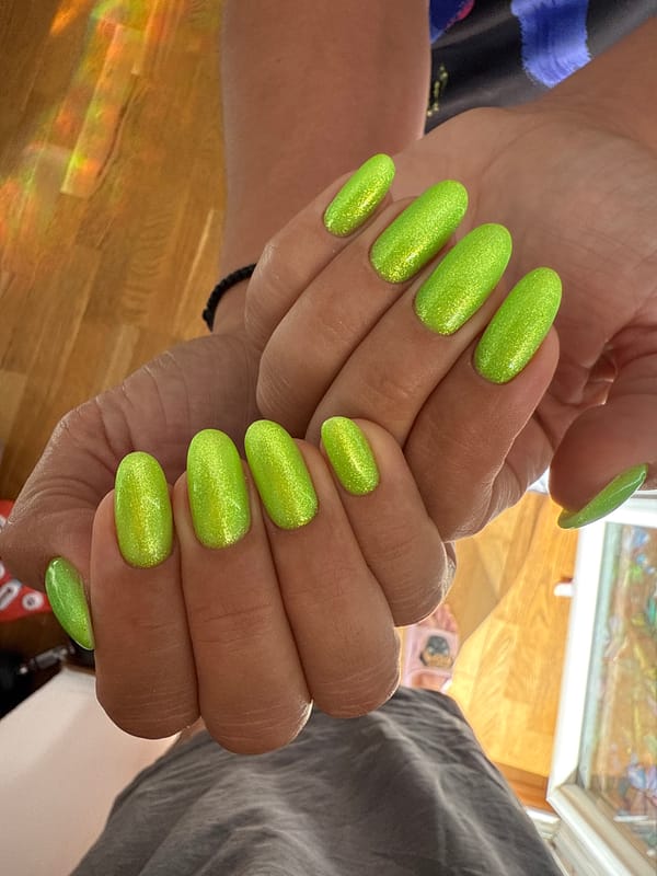 Person shows off bright green glittery manicure in photos