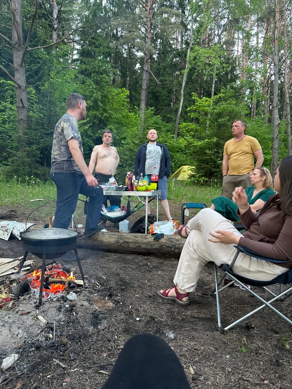 Camping group cooks outdoors in Belarus forest