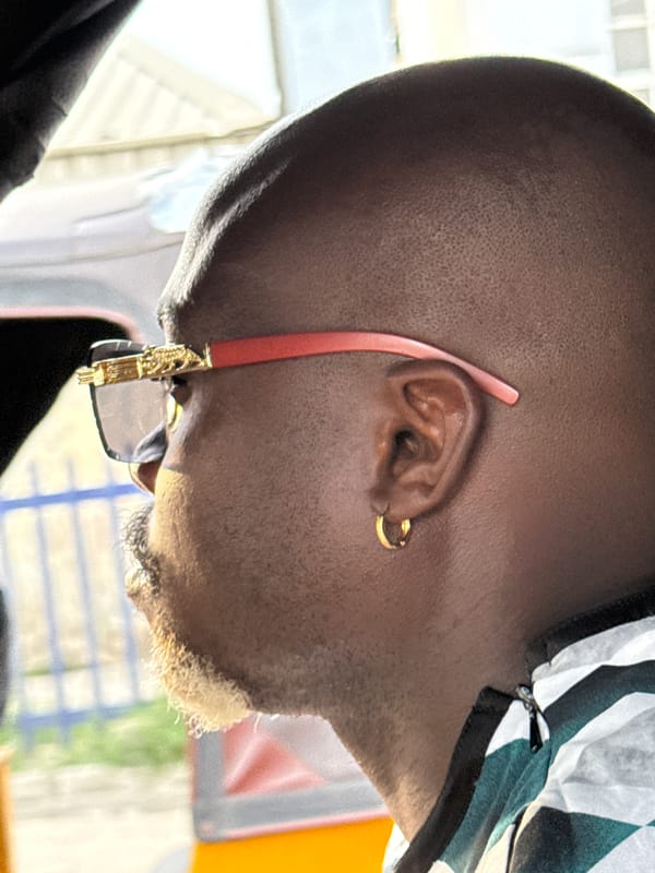 Man with gold earrings, red sunglasses photographed in Ikorodu