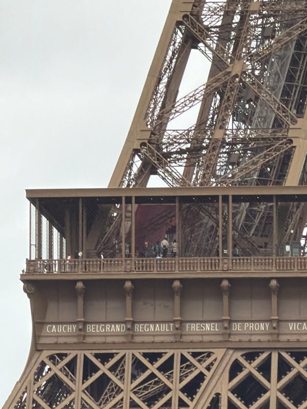 Tourist documents Eiffel Tower visit during overcast Paris afternoon