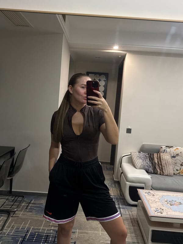 Mirror selfie in a Yiwu room, same outfit, same moment