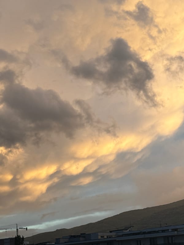 Dramatic storm clouds illuminate city skyline at sunset