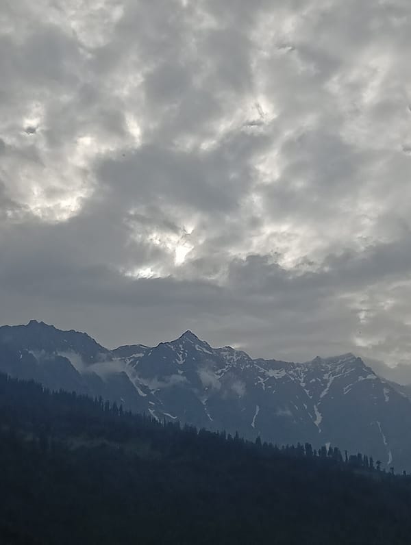 Snow-capped Himalayan peaks under brooding skies near Vashisht