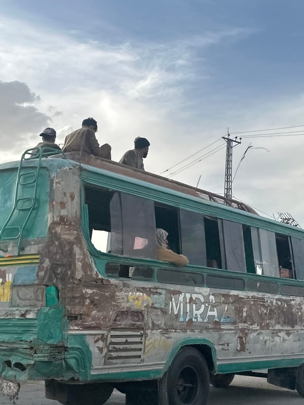 Men ride atop dilapidated bus in Quetta, Pakistan