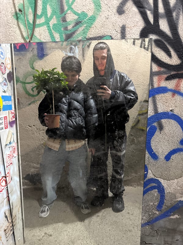 Two people pose by graffiti wall in Sofia