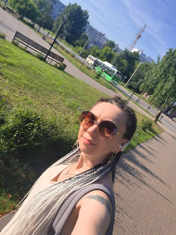 Selfie stop on a sunny urban walkway, peace sign out