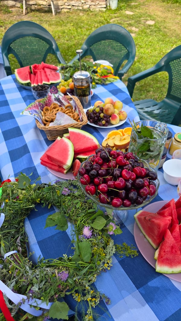 Summer picnic spread with food and wildflower arrangements in rural Russia