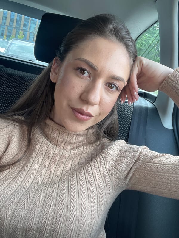Woman in beige sweater observed resting in car, Sofia