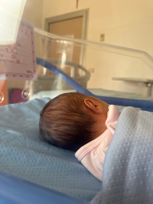 Newborn baby documented with family at Aprilia hospital
