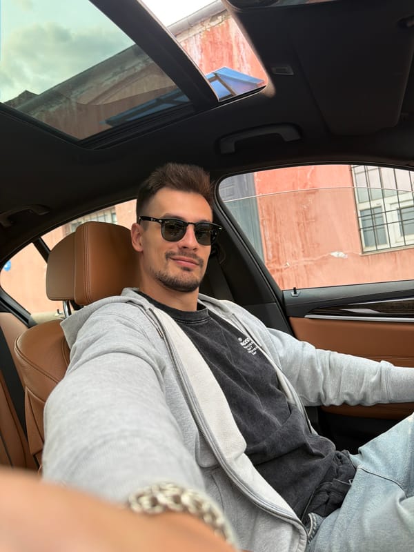 Car selfies in Krasnoyarsk, sunroof open, brick building outside