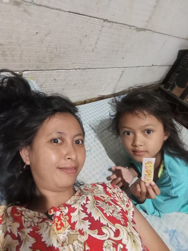 Woman and child share quiet moment on bed in Baron