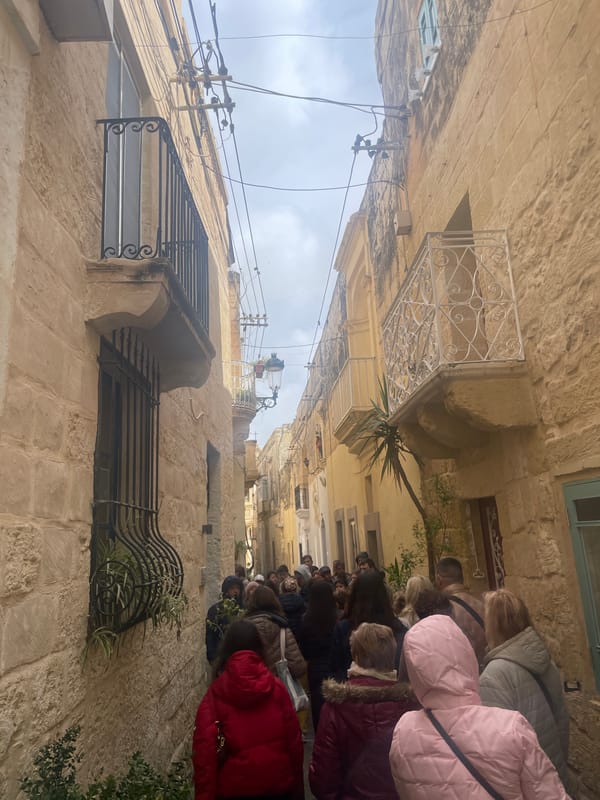 People gather on historic street in Rabat, Malta