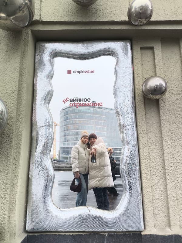 Two women photograph themselves in decorative mirror in Moscow