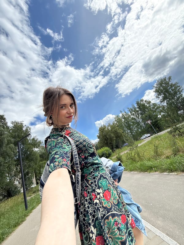 Selfie session in a park under a dramatic cloudy sky.