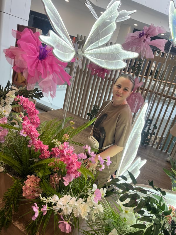 Shopping mall visitors photograph floral displays in Izhevsk