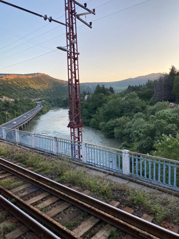 Bridge view over Tbilisi's river valley, green hills all around