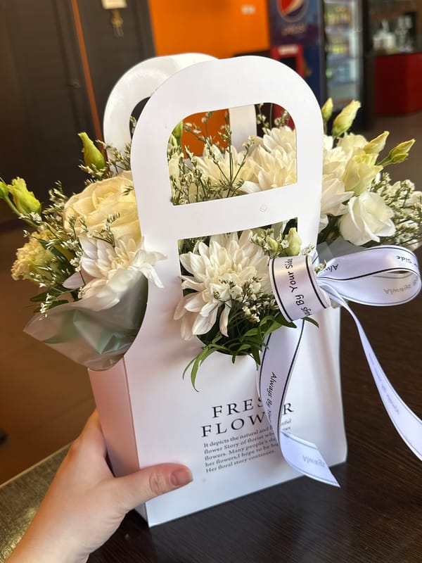 White flower arrangement documented with ribbon and pink ice cream
