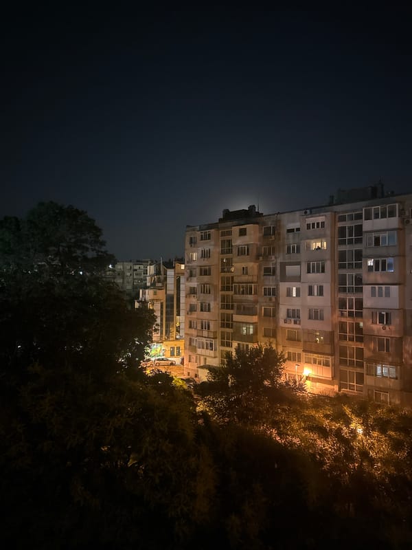 Nighttime views of a concrete apartment building under a full moon