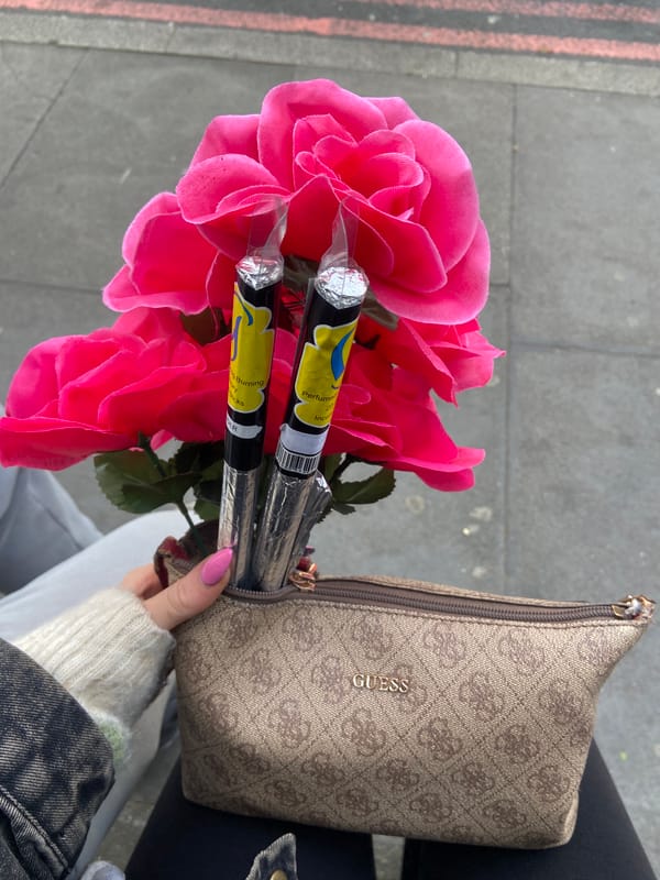 Person holds artificial roses and incense in London