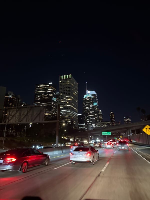 Early morning highway traffic flows past downtown Los Angeles