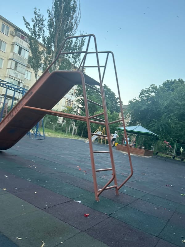 Afternoon at a Tiraspol playground, Soviet apartment blocks in the background.