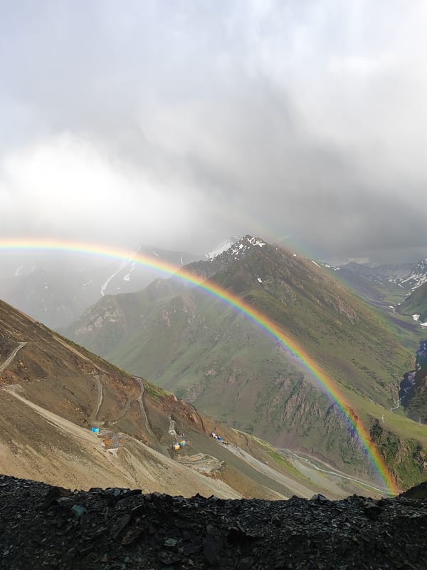 Double rainbow over a rocky Kyrgyzstan mountain valley