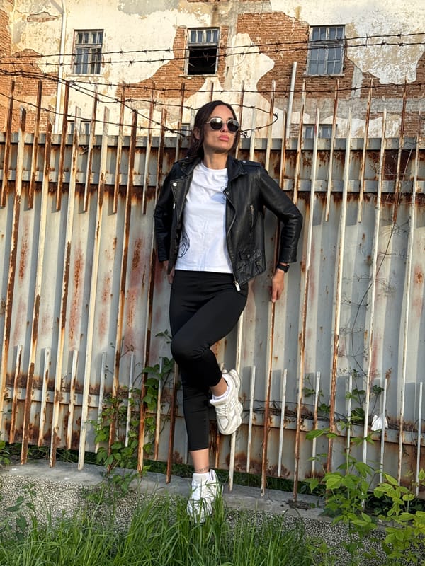 Woman poses for photos against metal fence in Pleven