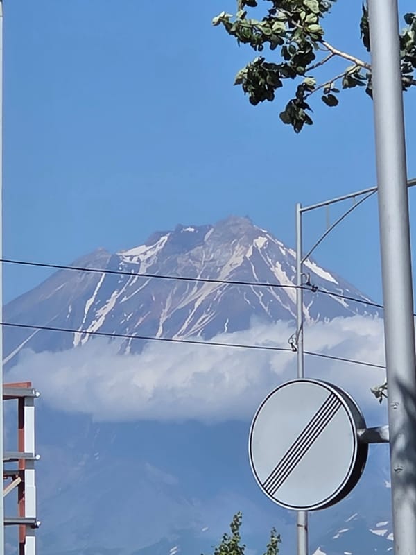 Snow-capped volcano seen from a roadside parking area