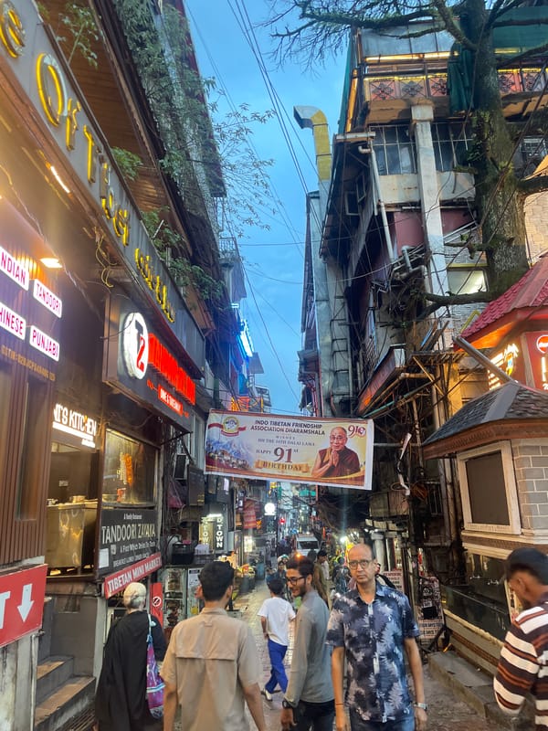 Bhagsu's wet cobblestone market street on a cloudy evening