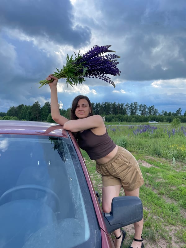 Woman enjoys photo session in Russian lupine flower field
