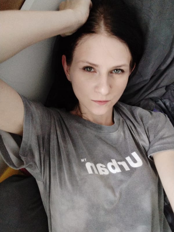 Casual self-portraits against a white wall in a grey tee