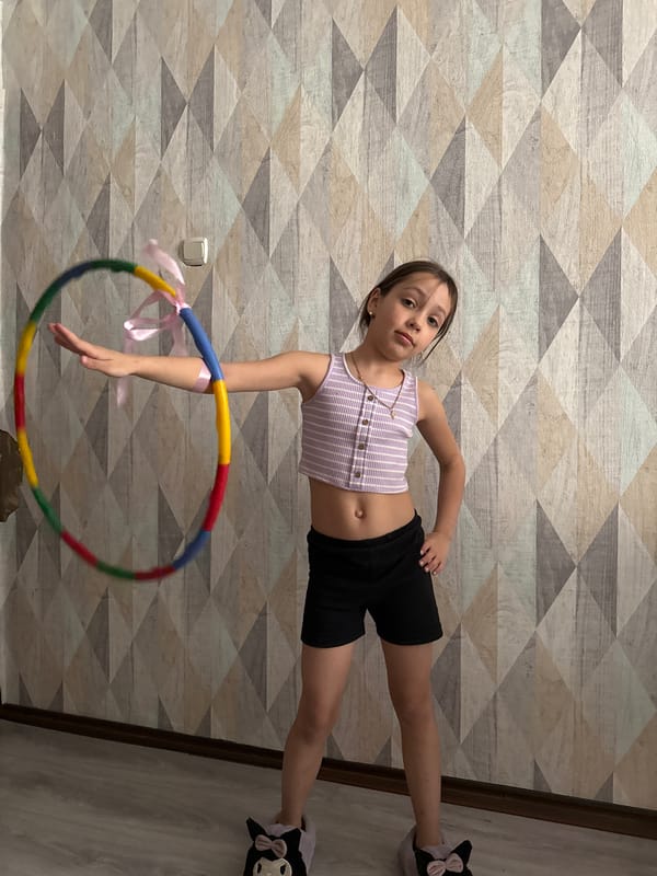 Girl practices gymnastics with dressed cat in Votkinsk home