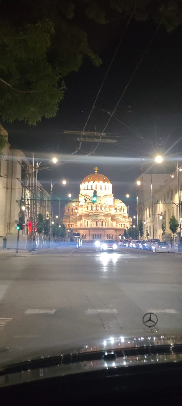 Nighttime scenes capture illuminated domed building amid city traffic